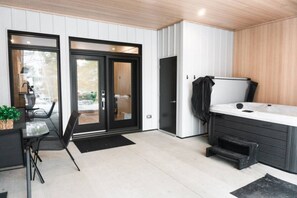 A modern kitchen with a black countertop, a sink, and a black cabinet. There is a window with a view of the outdoors. - Lynx Spa et confort à Orford (Orford)