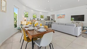 A modern living space with a dining area, kitchen, and seating area. - NEW 3BR Villa Salina Cerca | Close to Eduardo’s (Noord)
