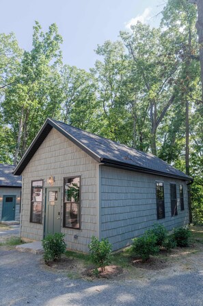 A small, single-story building with a gabled roof, a front door, and a small porch area.