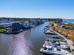 A marina with boats docked along a river, surrounded by residential buildings and a beach. - Bellflower - Cozy One Bedroom Villa at Petite Acres (New Buffalo)