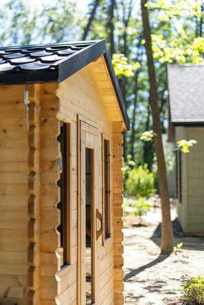 A wooden cabin with a gabled roof, a window, and a door.