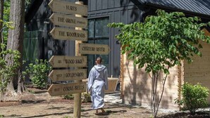 A wooden signpost with directions to various locations such as 'Yurts,' 'The Grove,' and 'The Woodlands.'