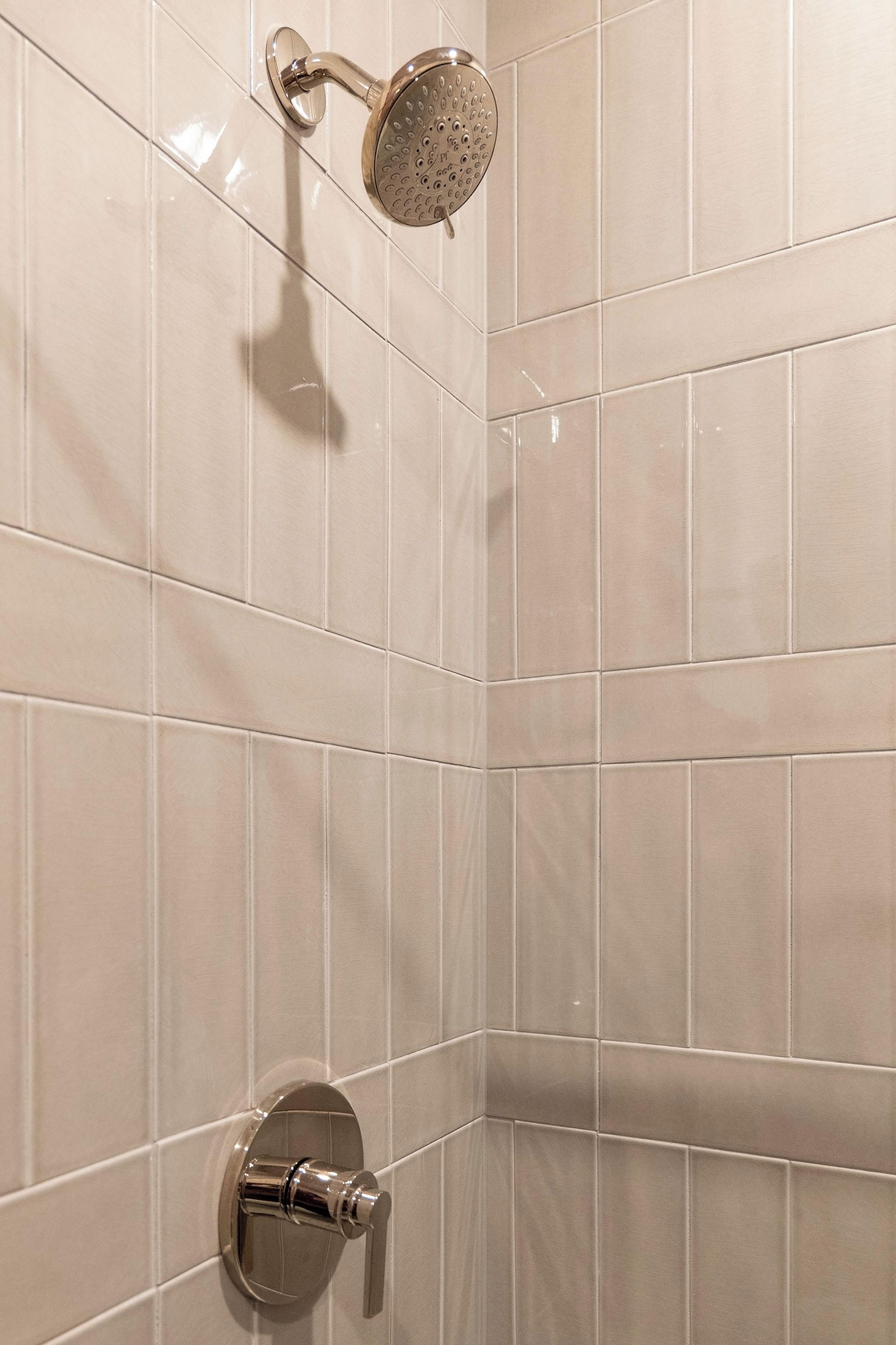 Een hoek van een badkamer met een douchekop en een kraan.