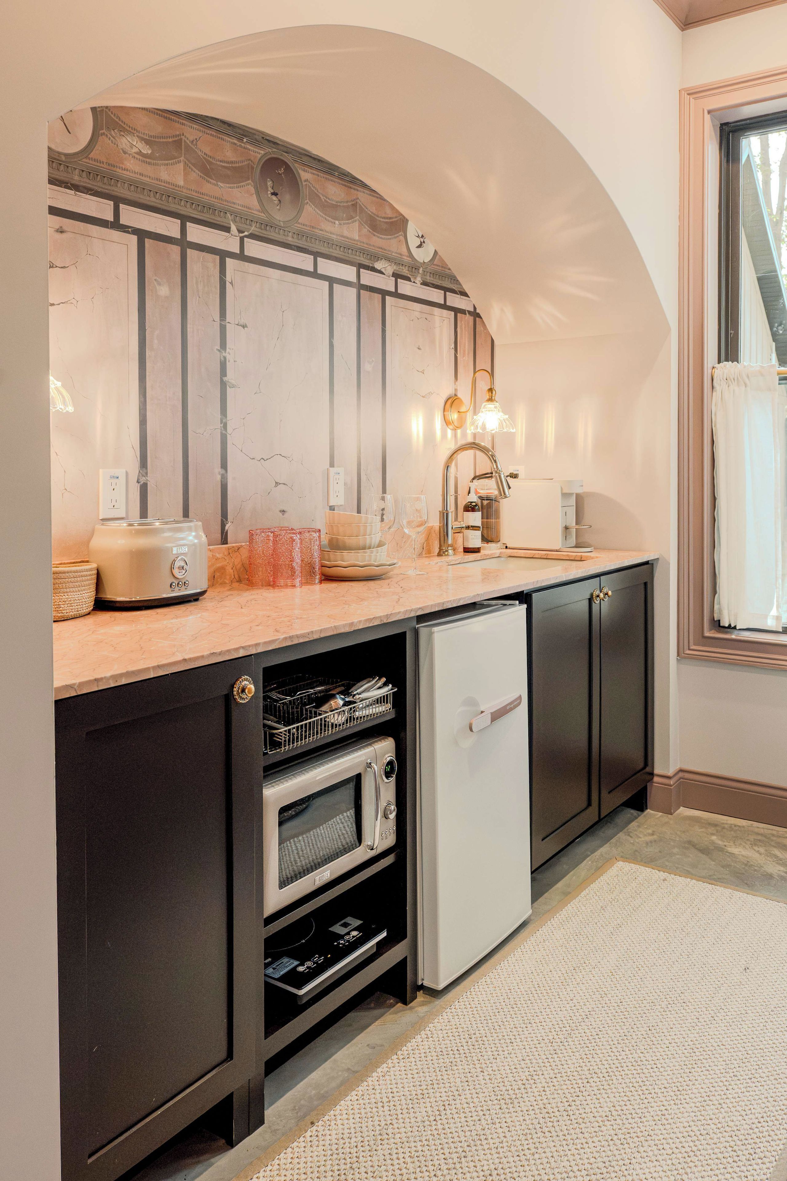 A compact kitchen with a built-in oven, a refrigerator, and a microwave.