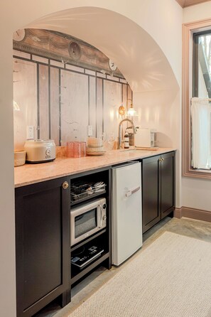 Eine kleine Küche mit Einbauofen, Kühlschrank und Mikrowelle.