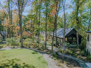 Área residencial com várias casas, um espaço coberto para sentar ao ar livre e um gramado bem cuidado.