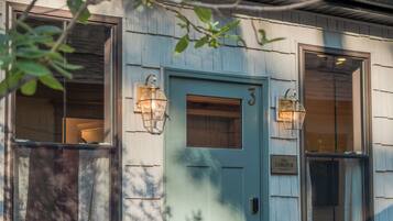A house with a green door, two windows with lanterns, and a number '3' on the door.