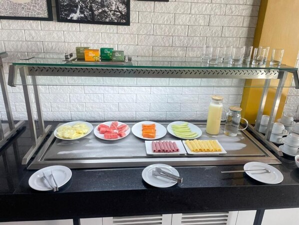 A buffet counter with various food items and condiments. - Star Hotel (Limoeiro)