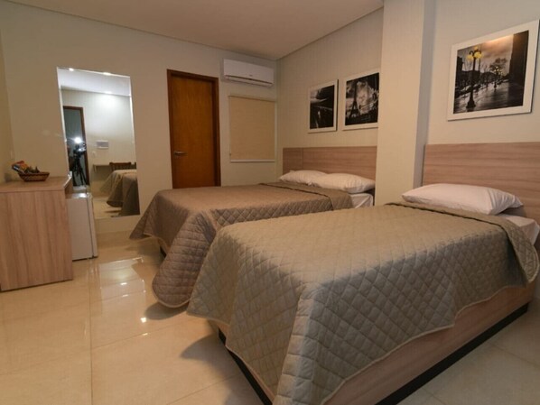 A hotel room with two beds, a desk, and a mirror. - Star Hotel (Limoeiro)