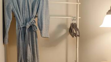 Un bagno con un porta asciugamani che contiene un accappatoio e degli asciugamani.