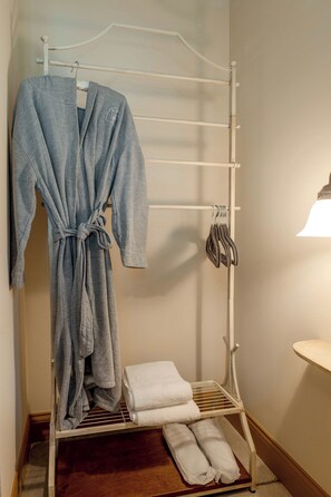 A bathroom with a towel rack holding a bathrobe and towels.
