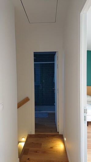 A narrow hallway with wooden flooring and a door leading to a room with a dark tiled wall. - 3-bedroom house, 115 m², with a garden in Saint-Malo, near Saint-Servan   (Saint-Malo)