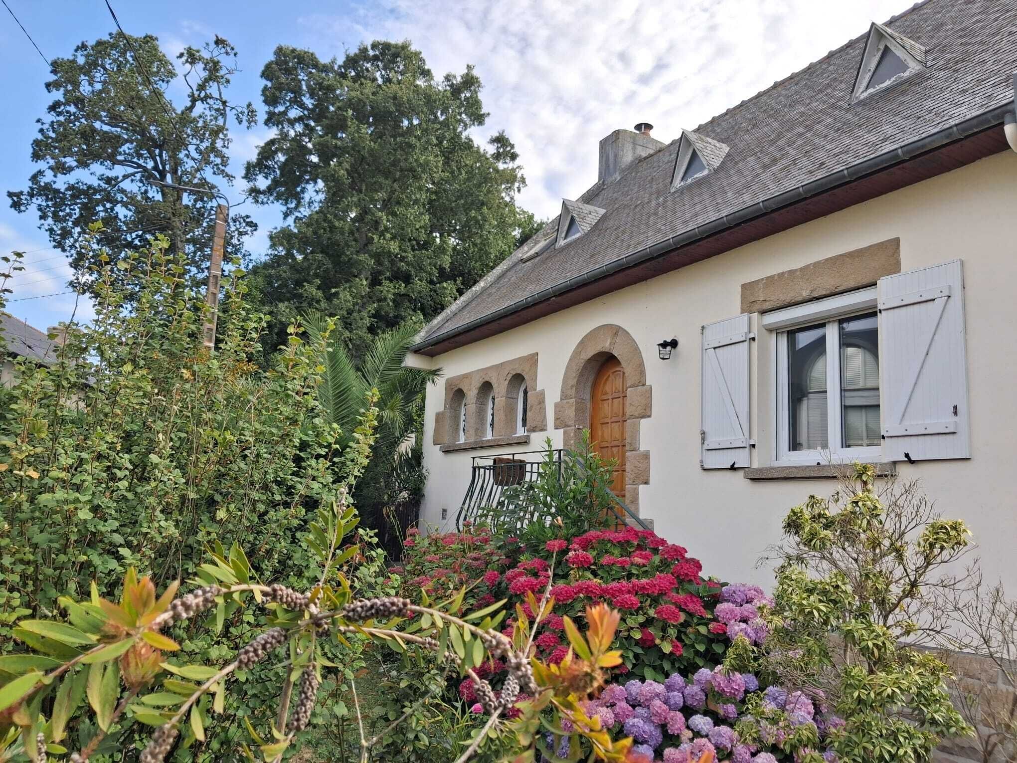 Ein Haus mit Garten, einer Holztür und einem Fenster mit Rollläden.