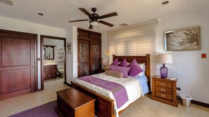Ein Schlafzimmer mit Bett, Nachttisch, Lampe und Deckenventilator.