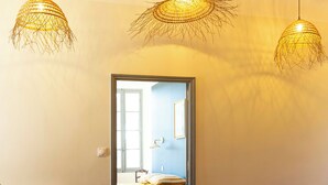 Quarto com radiador, sofá e tapete. Três luminárias pendentes.