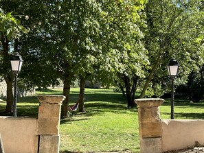 A park with stone lamp posts, lush green grass, and trees. - Elegant Provençal country house with a large wooded lot and an exceptional pool   (Trets)
