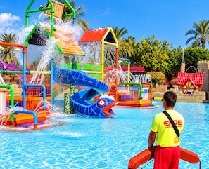 A water park with a lifeguard present, a blue slide, and a pool area. - La Macarena Torrevieja (Torrevieja)