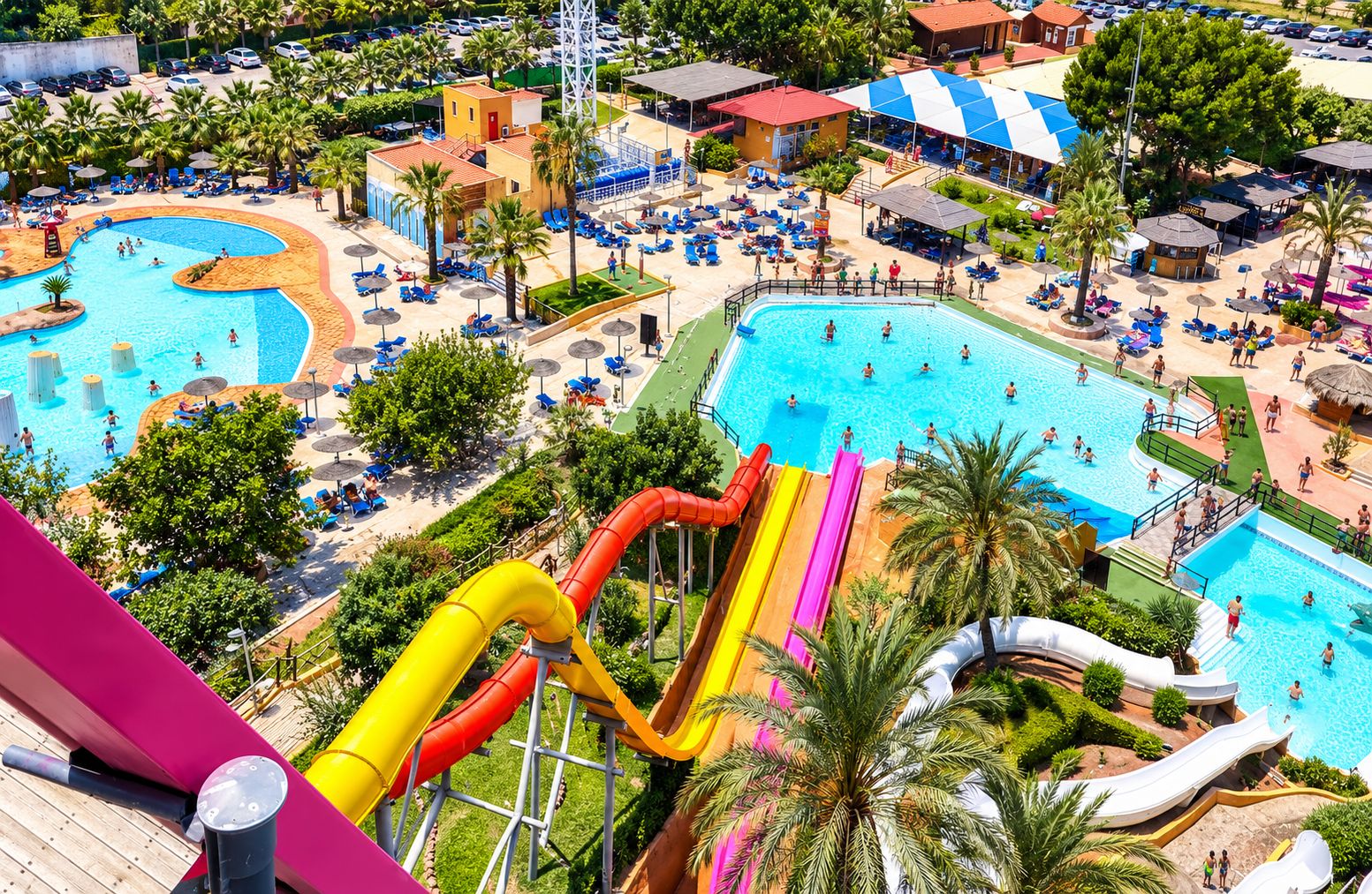 Un resort con diverse piscine, un parco acquatico con scivoli e aree relax con ombrelloni.