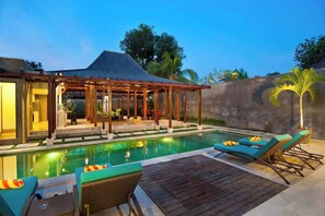 A poolside area with lounge chairs and a covered seating area. - Spacious 4BR Garden Villa | Walk To Legian Beach (Legian)