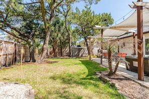 Ein Garten mit Terrasse, Gartenmöbeln und Holzzaun.