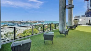 A balcony with artificial grass, outdoor furniture, and a view of a marina and cityscape. - 47th Floor Miami Studio w/ Balcony & Rooftop Pool (Miami)