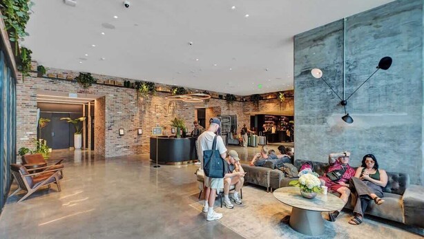 A spacious lobby with a brick wall, a reception desk, and seating areas. - 47th Floor Miami Studio w/ Balcony & Rooftop Pool (Miami)