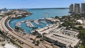 A marina with boats docked, a large Ferris wheel, and a cityscape with high-rise buildings. - 47th Floor Miami Studio w/ Balcony & Rooftop Pool (Miami)