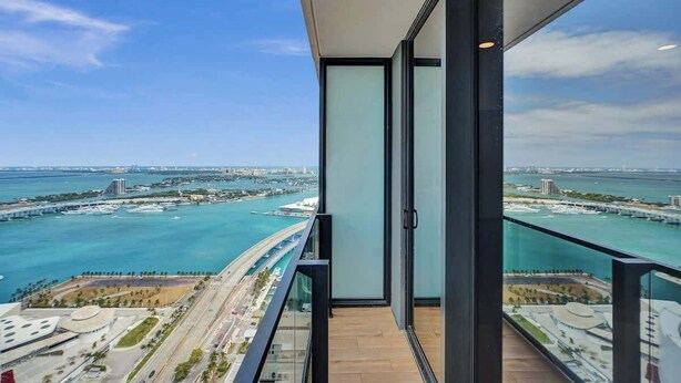 Ein Balkon mit Blick auf eine Küstenstadtlandschaft, darunter eine Brücke und ein Yachthafen.