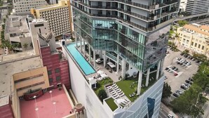 Ein modernes Hotel mit Dachpool, mehreren Etagen und einer Glasfassade.