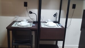 A dining area with a dark wooden table, two chairs, and a small shelf above. - Smart Malls (Belém)