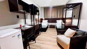 A compact hotel room with a kitchenette, a desk, two beds, a sofa, and a mirror. - Smart Malls (Belém)
