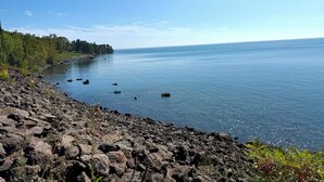 Una costa rocosa con aguas tranquilas y cielo despejado.