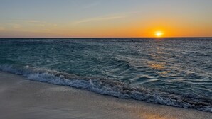 A beach with waves at sunset. - Ocean views of #1 rated Eagle Beach from 5th floor (Eagle Beach, Oranjestad)