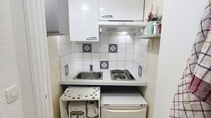 A compact kitchen with white cabinets, a sink, a stove, and a refrigerator. - Studio Cannes, 350 m from the sea (Cannes)