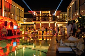 Un espace aménagé au bord de la piscine, avec un bar et des chaises longues.