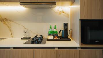 Una cocina moderna con armarios de madera, encimera blanca y microondas integrado.