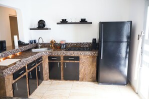 A kitchen with a black refrigerator, a sink, and a stove. There are cabinets and a countertop. - Private, Cozy 1-bedroom apartment with unobstructed views in serene Patillas (Patillas)