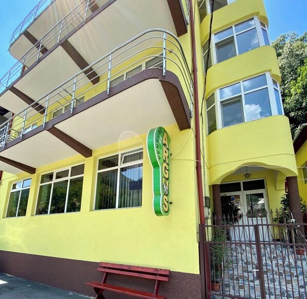 A yellow building with a green sign reading "PENSIUNE ARGENTINA."