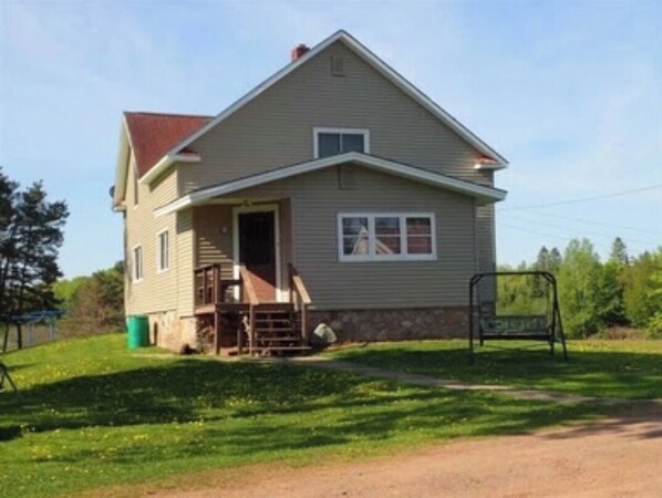 A single-story house with a front porch, a small set of stairs, and a visible garage door.