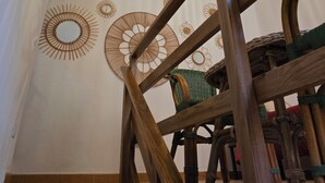 Eine Treppe mit Holzgeländer, einem grünen Stuhl und Wanddekorationen.