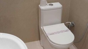A bathroom with a toilet, a bidet, and a sink. - Hotel advantage inn  (Prayagraj)