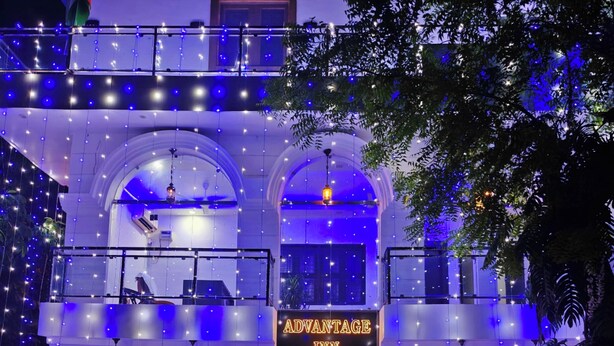 A building with a sign reading 'ADVANTAGE INN' and a balcony with string lights. - Hotel advantage inn  (Prayagraj)