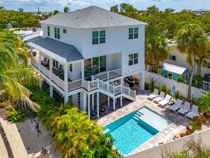 A two-story house with a balcony, a swimming pool, and a garden. - The Shell House • 4-Min Walk to the Beach • Private Heated Pool • 3 Kings (Fort Myers Beach)