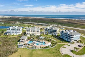 Ein Resort mit mehreren Gebäuden, einem Swimmingpool und Blick aufs Meer.