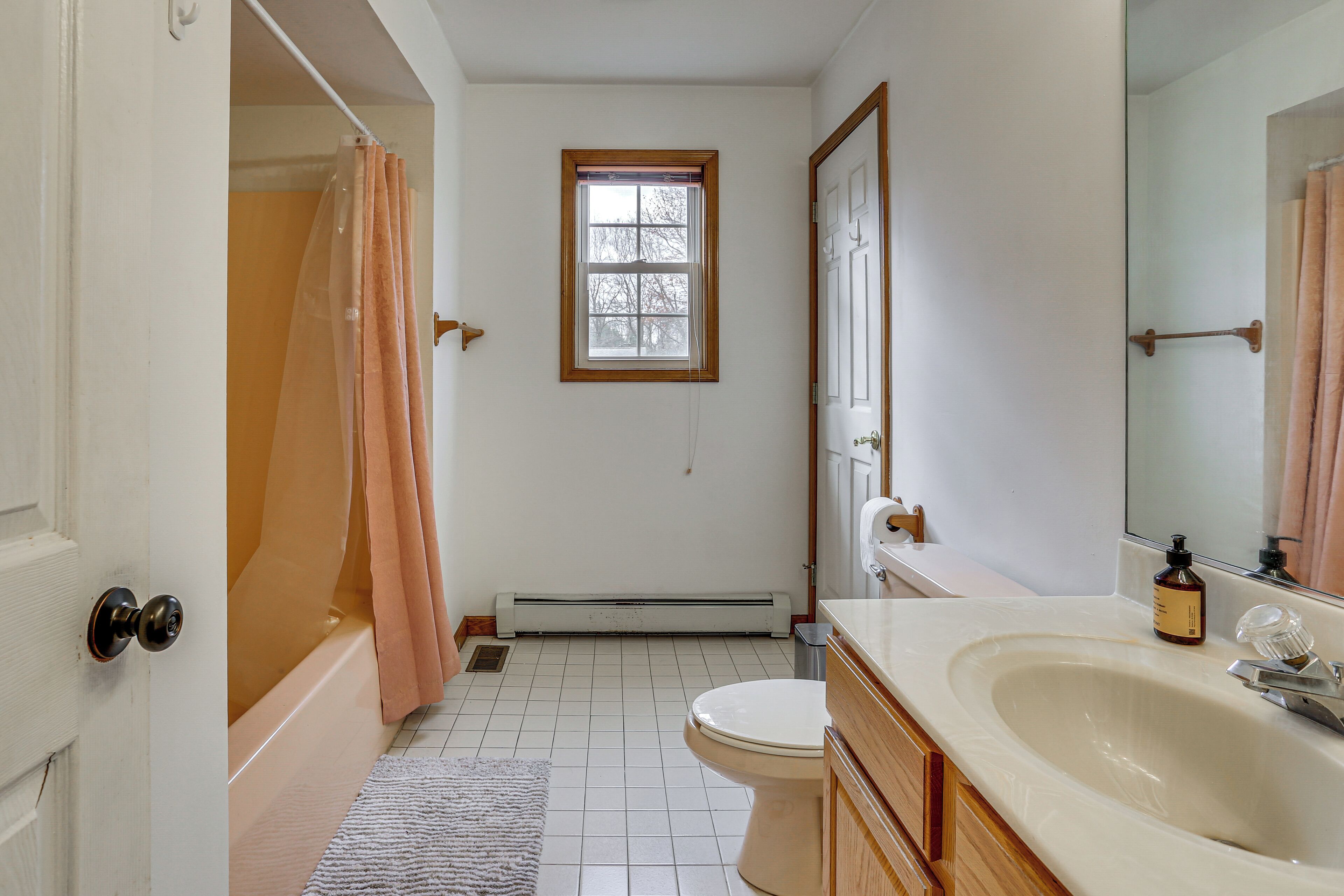 A bathroom with a bathtub, toilet, and sink.