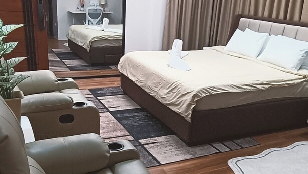 Ett modernt hotellrum med en stor säng, en soffa, ett skrivbord och en spegel.