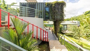A modern building with a staircase, a red railing, and greenery. - Mata e’ Plátano Guesthouse Suite private pool (Mata de Platano)