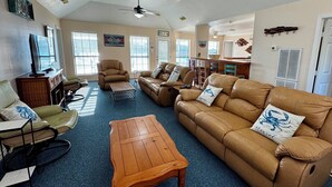 A spacious living room with leather sofas, a wooden coffee table, and a television. - Matagorda-Stunning Waterfront Views-Swim Spa-Private Pier-Relax (Matagorda)