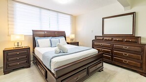 Une chambre à coucher avec un grand lit, une commode, un miroir et deux tables de chevet.