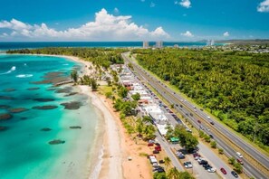 Uma estrada costeira com uma praia de um lado e uma floresta densa do outro.